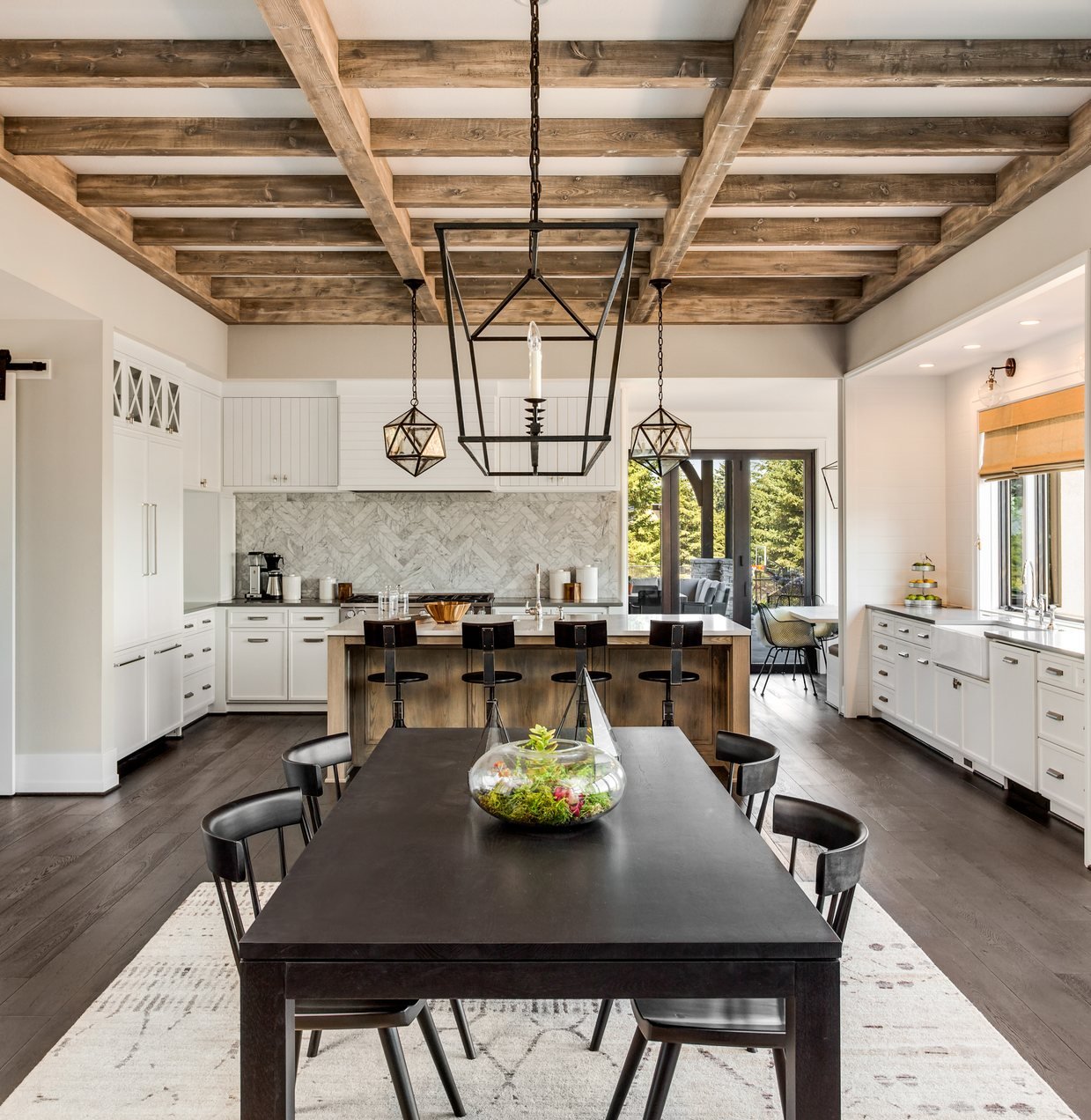 Open-plan kitchen and dining area with exposed wood ceiling beams